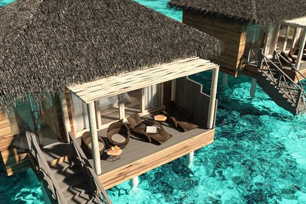 Überwasser Bungalow im You & Me Maldives mit Holzbrücke und Sonnenliegen im Wasser
