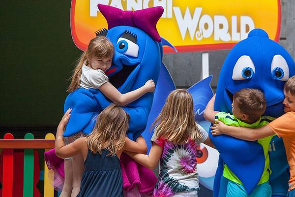 Kinder umarmen Fanchi Welt Figuren im Lopesan Costa Meloneras Resort & Spa