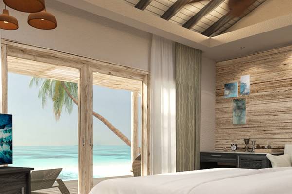Schlafzimmer mit Meerblick im You & Me Maldives Hotel, zeigt ein großes Bett mit weißen Laken.