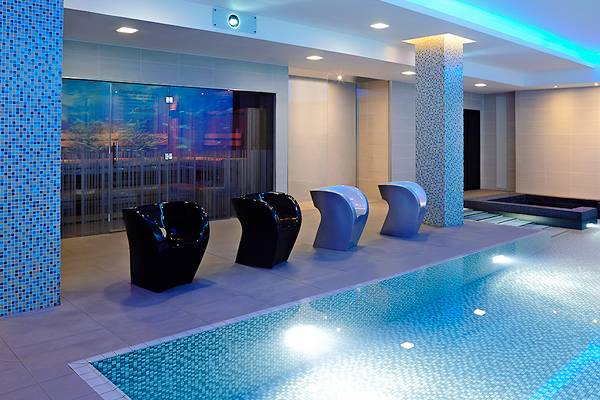 Saunabereich des Novotel London Blackfriars mit einem Pool und modernen Möbeln.