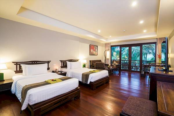 Doppelzimmer im Khao Lak Laguna Resort mit zwei Betten, Balkon und Blick auf den Garten.