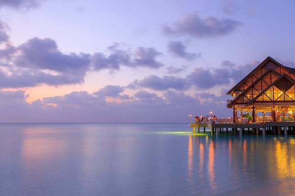 Anantara Dhigu Maldives Resort Gebäude am Wasser bei Sonnenuntergang