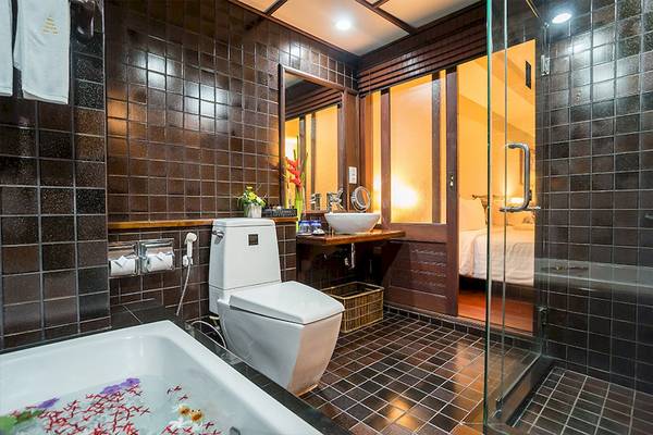 Badezimmer des Khao Lak Laguna Resorts mit Badewanne, Toilette und Dusche.