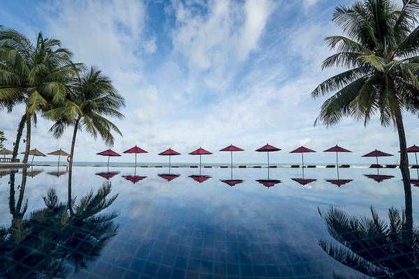 Außenpool des Khao Lak Laguna Resorts mit roten Sonnenschirmen und Palmen