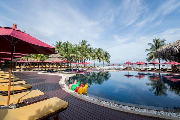 Außenpool mit gelben Sonnenliegen und roten Sonnenschirmen im Khao Lak Laguna Resort.