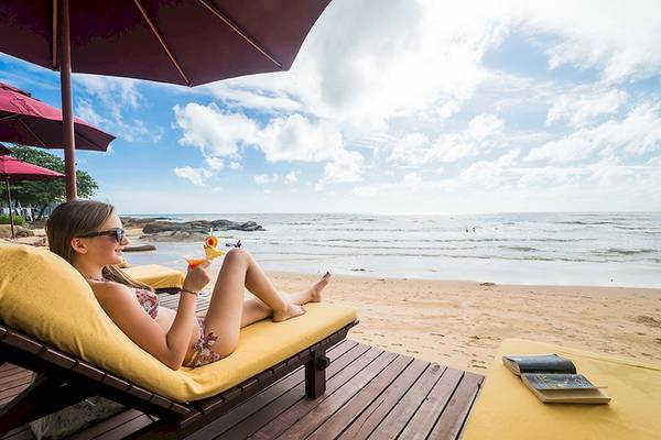 Frau im Bikini liegt auf einem Liegestuhl am Strand des Khao Lak Laguna Resorts