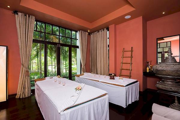 Spa-Behandlungsraum im Khao Lak Laguna Resort mit zwei Behandlungstischen und großen Fenstern.