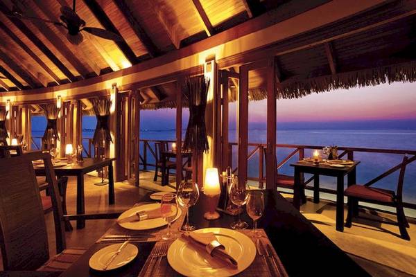 Innenansicht des Restaurants im Anantara Dhigu Maldives Resort mit Blick auf das Meer.