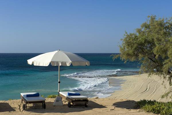Strand mit Sonnenliegen und Sonnenschirm am Grecian Sands Hotel