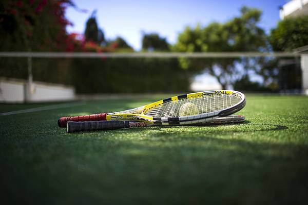 Tennisschläger auf dem Rasen eines Tennisplatzes im Freien.