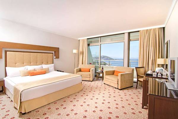 Deluxe Zimmer im KoruMar Hotel De Luxe mit Meerblick, großen Fenstern und modernen Möbeln.