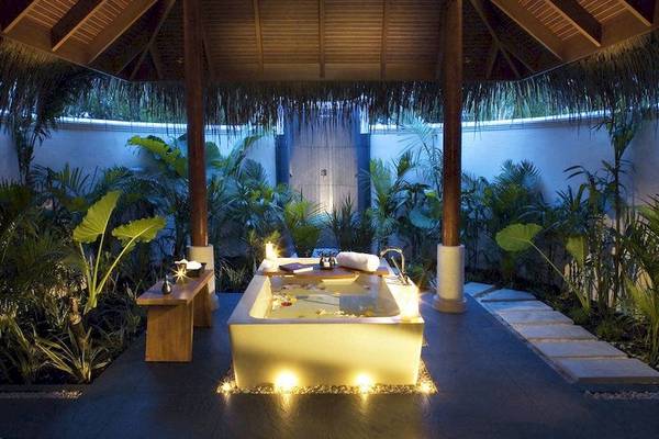 Außen-Whirlpool des Anantara Dhigu Maldives Resorts, umgeben von Pflanzen und mit Beleuchtung.