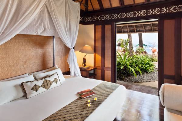 Zimmer im Novotel Bali Benoa mit einem Bett, einer Lampe und einer Aussicht auf den Garten und das Meer.