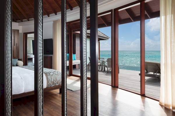 Schlafzimmer im Anantara Dhigu Maldives Resort mit Meerblick und großer Terrasse.