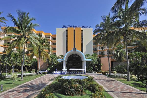 Vorderansicht des Melia Varadero Hotels mit gepflastertem Weg und Palmen