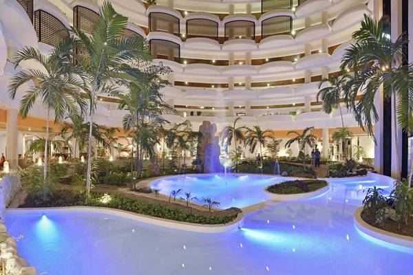 Innenansicht des Pools im Melia Varadero Hotel, umgeben von Palmen und Pflanzen.
