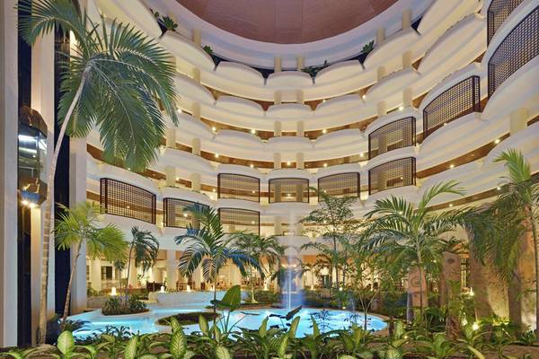 Innenhof des Melia Varadero Hotels mit Swimmingpool und tropischen Pflanzen.