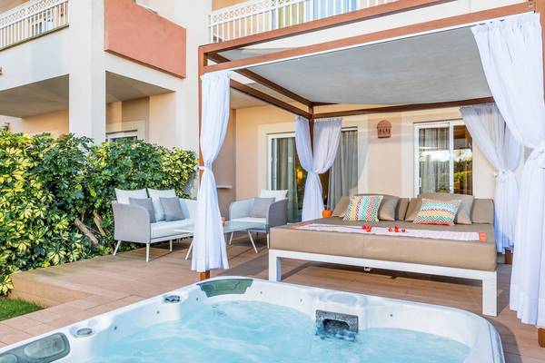 Terrasse im Viva Blue & Spa Hotel mit einem Jacuzzi und einem Lounge-Bereich.