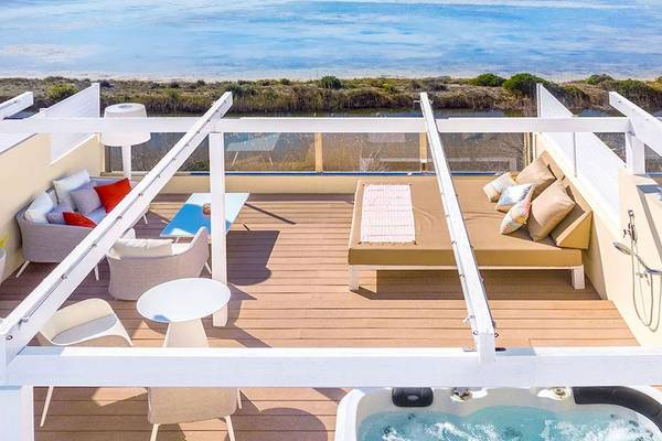 Dachterrasse des VIVA Blue & Spa Hotels mit Blick auf das Meer, Jacuzzi und modernen Möbeln.
