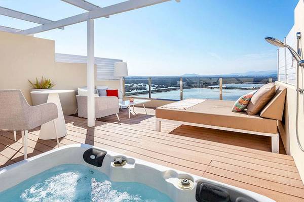 Terrasse des VIVA Blue & Spa Hotels mit Whirlpool und Aussicht auf Wasser und Berge