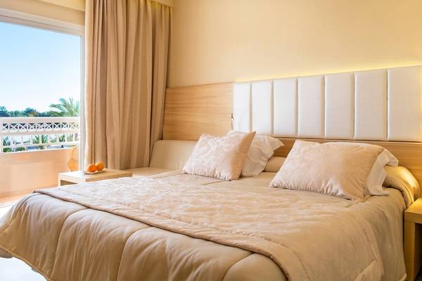 Schlafzimmer im VIVA Blue & Spa Hotel mit Blick auf den Balkon und die Palmen draußen