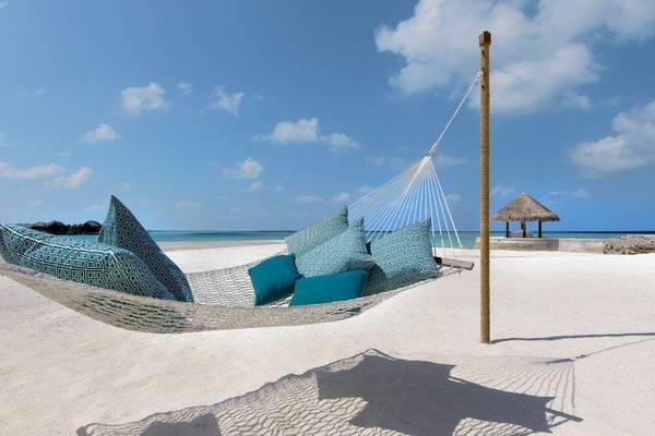 Hängematte am Strand des Anantara Dhigu Maldives Resorts mit blauen Kissen
