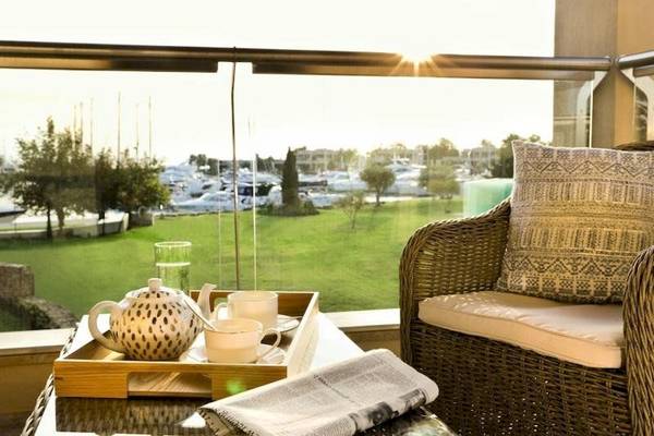 Aussicht von der Terrasse des Porto Sani Hotels mit einem Tisch, Tassen und Zeitung.
