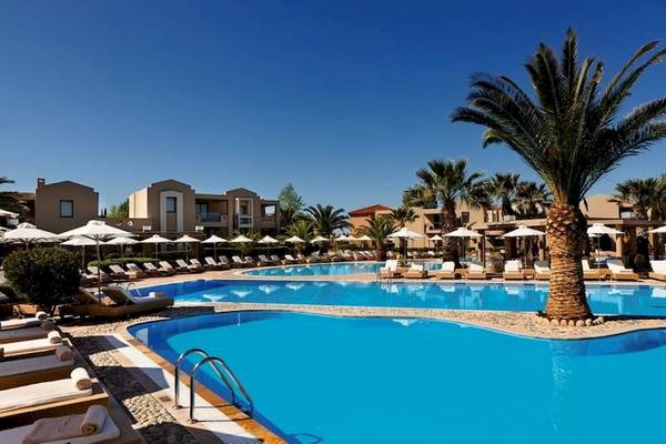 Außenpool des Porto Sani Hotels mit Palmen und Liegen im Freien