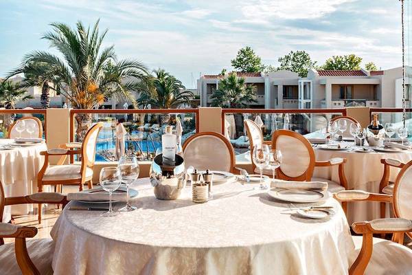 Porto Sani Hotel Terrasse mit gedeckten Tischen und Blick auf einen Pool