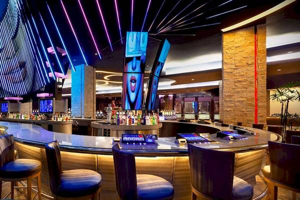 Bar im Hard Rock Hotel & Casino Punta Cana mit vielen Flaschen und Bildschirmen