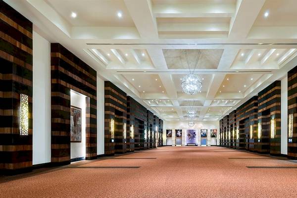 Innenansicht des Hard Rock Hotel & Casino Punta Cana mit langen Flur und braunem Teppichboden.