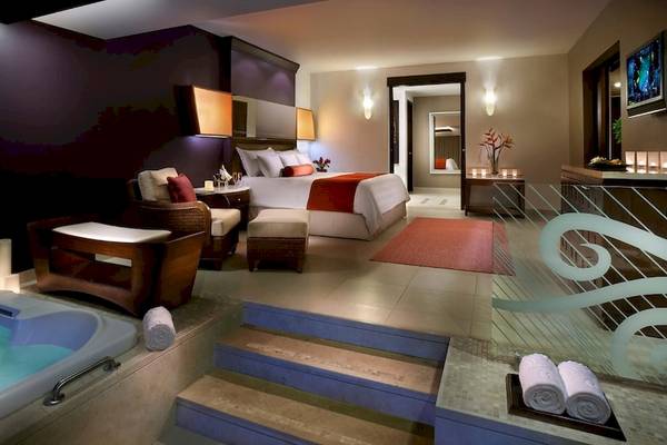 Innenansicht der Suite im Hard Rock Hotel & Casino Punta Cana mit Badewanne, Bett und Lounge-Bereich.