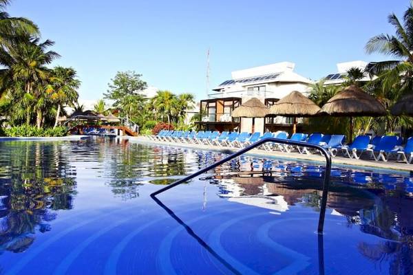 Außenpool des Sandos Caracol Eco Resorts mit blauen Sonnenliegen und Sonnenschirmen.