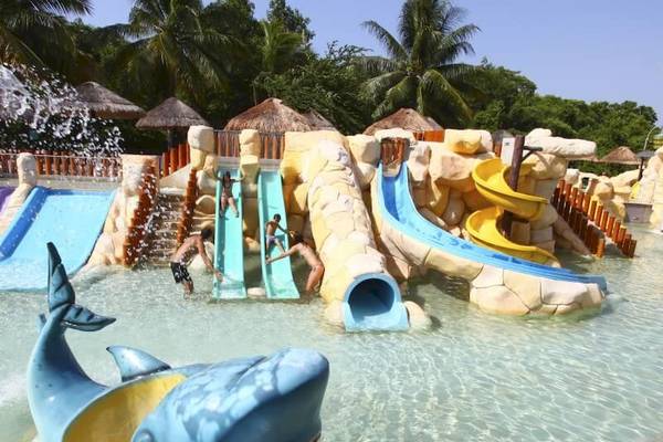 Wasserpark im Sandos Caracol Eco Resort mit Rutschen und blauem Delphinspielzeug.