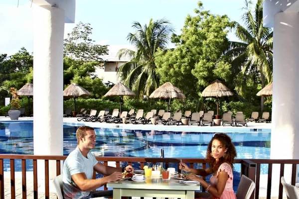Paar beim Essen am Pool im Sandos Caracol Eco Resort