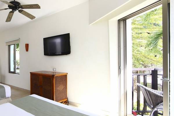 Doppelzimmer im Sandos Caracol Eco Resort mit zwei Betten, Klimaanlage, Fernseher und Balkon.