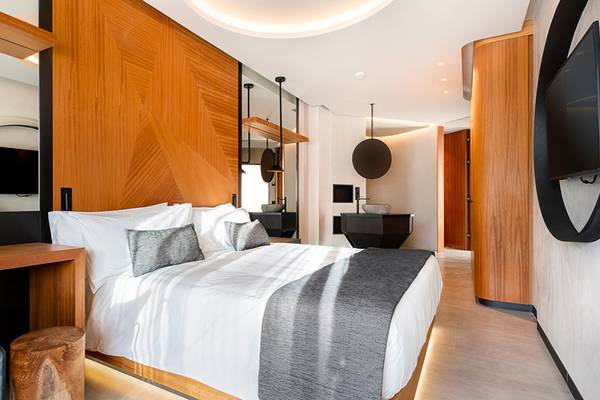Hotelzimmer im Faro, a Lopesan Collection Hotel mit einem großen Bett, weißen Kissen und einer grauen Decke.