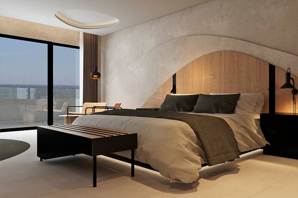 Hotelzimmer mit Bett, Nachttischen und Ausblick auf den Ozean