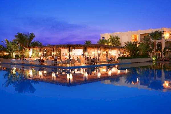 Außenbereich des Jaz Aquamarine Resorts bei Nacht mit illuminierten Gebäuden und beleuchtetem Pool.