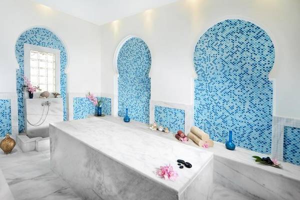 Ein Badezimmer im Jaz Aquamarine Resort mit blauen Fliesen und Marmoroberflächen.