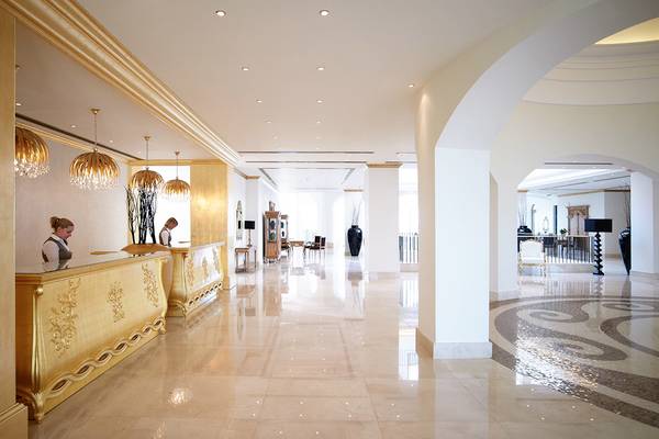 Empfangshalle des Mitsis Laguna Resorts mit goldenen Details und Marmorboden.