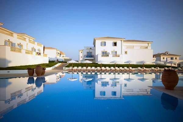 Außenbereich des Mitsis Laguna Resorts mit Swimmingpool und Hotelgebäuden.