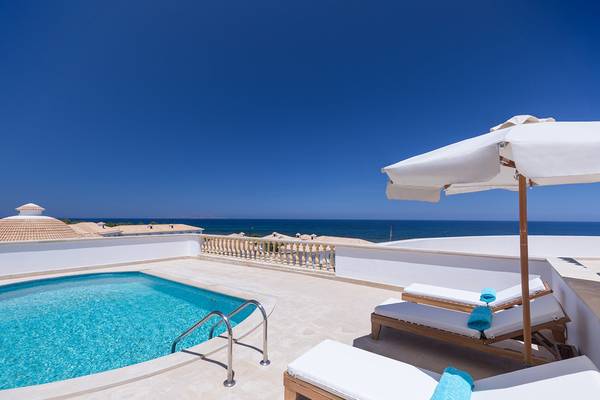 Terrasse des Mitsis Laguna Resorts mit Pool und Blick auf das Meer.