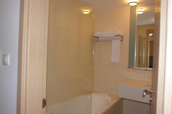 Badezimmer im Agua Hotels Sal Vila Verde mit Badewanne, Handtüchern und Spiegel.