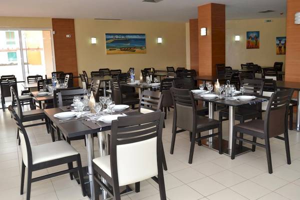 Innenansicht des Restaurants im Agua Hotels Sal Vila Verde mit eingerichteten Tischen und Stühlen.
