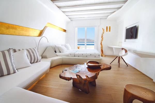 Schlafzimmer im Aeolos Beach Resort auf Korfu mit weißen Möbeln und Holzboden.