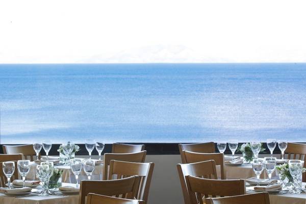 Meerblick-Restaurant im Aeolos Beach Resort auf Korfu mit gedeckten Tischen und Blick auf das Meer.