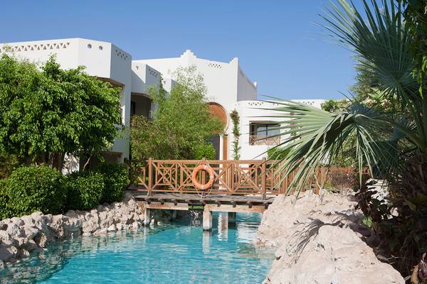 Außenansicht des Pools der Ghazala Gardens Anlage mit einem hölzernen Steg und einem Rettungsring.