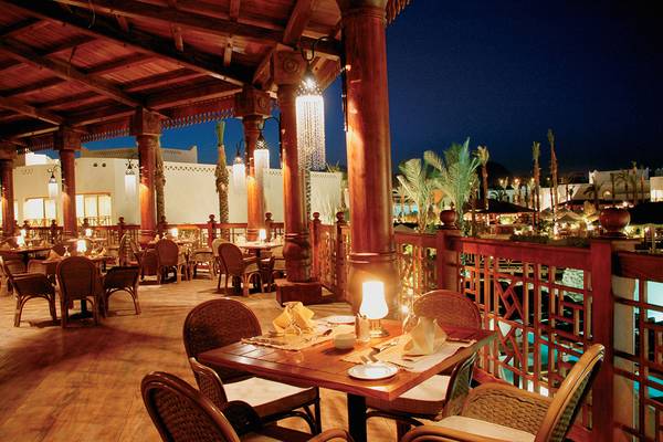 Beleuchtete Terrasse des Ghazala Gardens Hotels mit abendlichem Ambiente und beleuchteten Säulen.