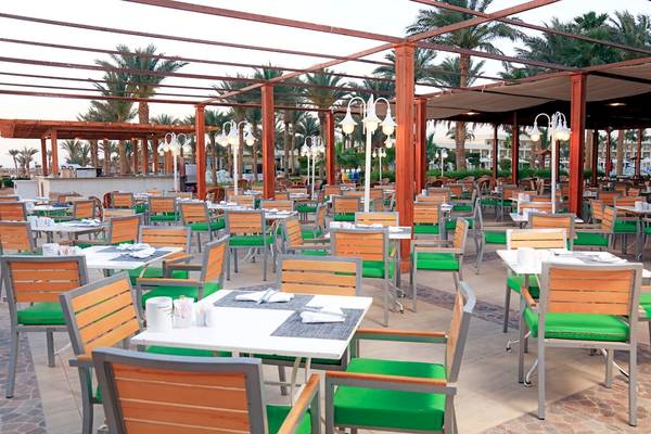 Außensitzplätze im Restaurant des LABRANDA Royal Makadi Hotels, umgeben von Palmen und Schirmen.